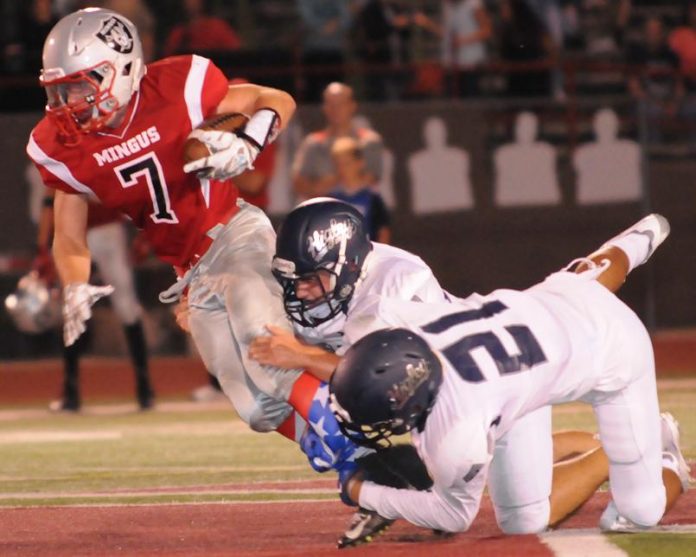 Mingus Union High School junior Tyler Kelly gets dragged down by tacklers from Higley High School, of Gilbert. Although the Marauders started the season in the top 10, their second straight loss, 13-6, at Cactus Shadows High School has been part of an 0-6 start this fall for Verde Valley high school teams.