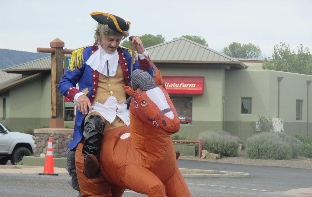 A man in colonial costume and riding an inflatable horse down Finnie Flat Road at the 70th Annual Fort Verde Parade on Saturday, Oct. 10, 2026.