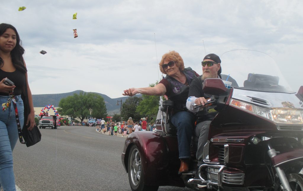 A woman tosses candy from a motorcyle at the 70th Annual Fort Verde Parade on Saturday, Oct. 10, 2026.
